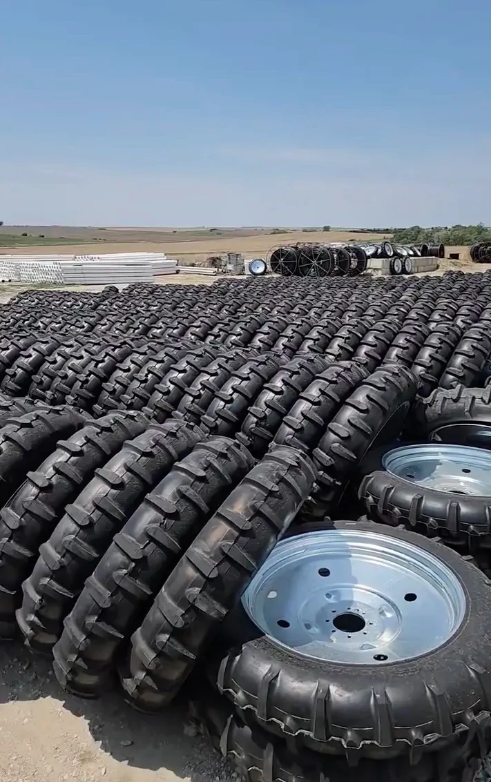 Stacked center pivot tires and wheel rims in the yard