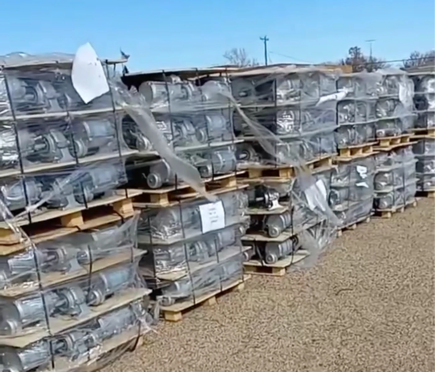 Pallets of shrink-wrapped pivot gearboxes and parts in the yard