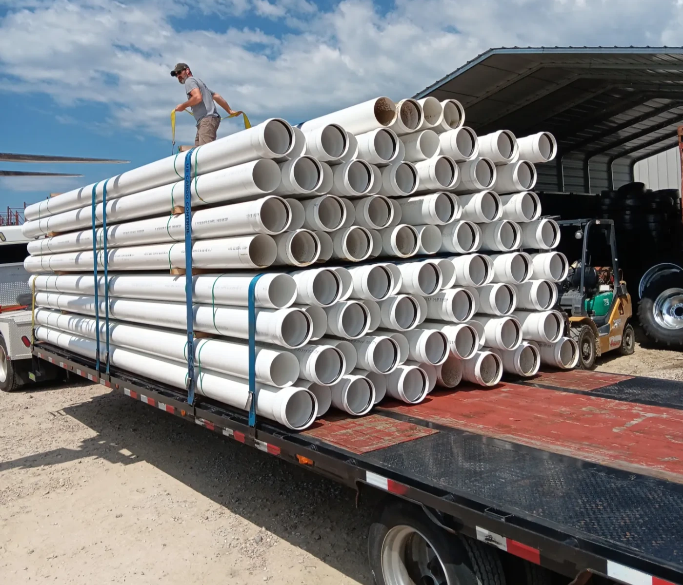 Flatbed truck loaded with stacks of irrigation pipe